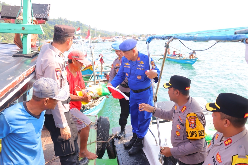 Polresta Bandar Lampung Bagikan 80 Bendera Merah Putih dan Sembako kepada Nelayan di Teluk Lampung