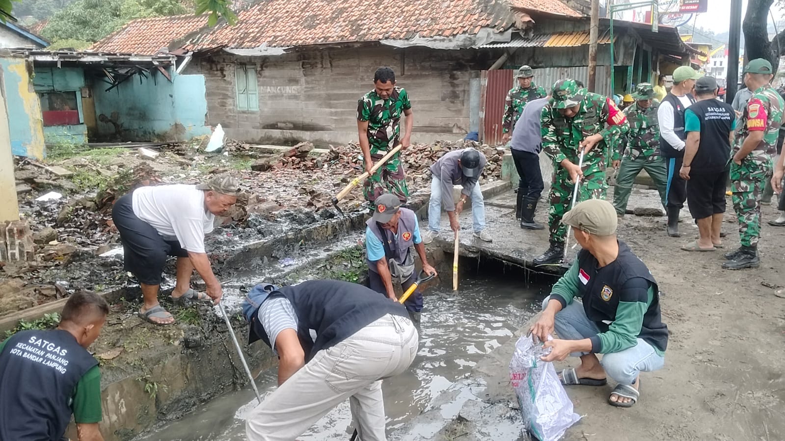 Babinsa dan Warga Kelurahan Pidada Bersinergi Bersihkan Drainase Cegah Banjir