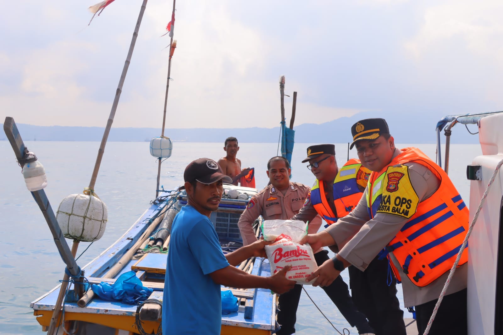 Pakai Kapal Patroli, Polresta Bandar Lampung Bagikan Bansos ke Nelayan di Tengah Laut