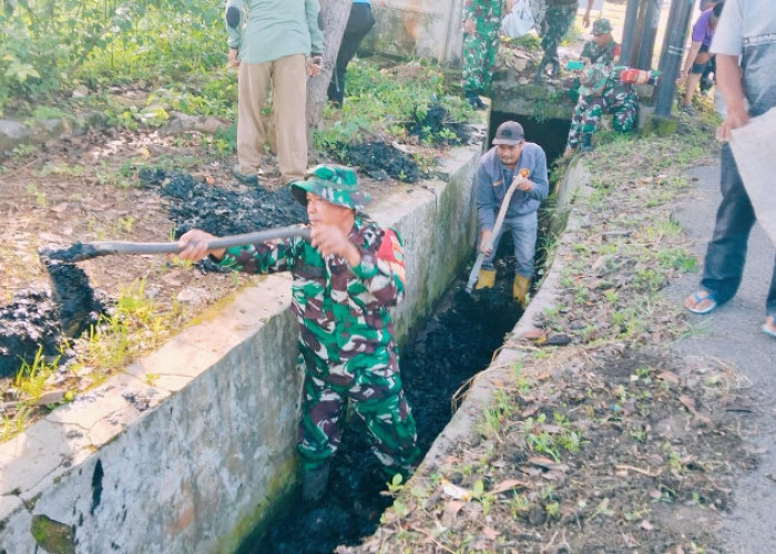 Babinsa Kalibalau Kencana Gotong Royong Bersihkan Drainase di Jalan Arif Rahman Hakim