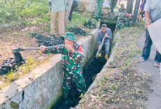 Babinsa Kalibalau Kencana Gotong Royong Bersihkan Drainase di Jalan Arif Rahman Hakim