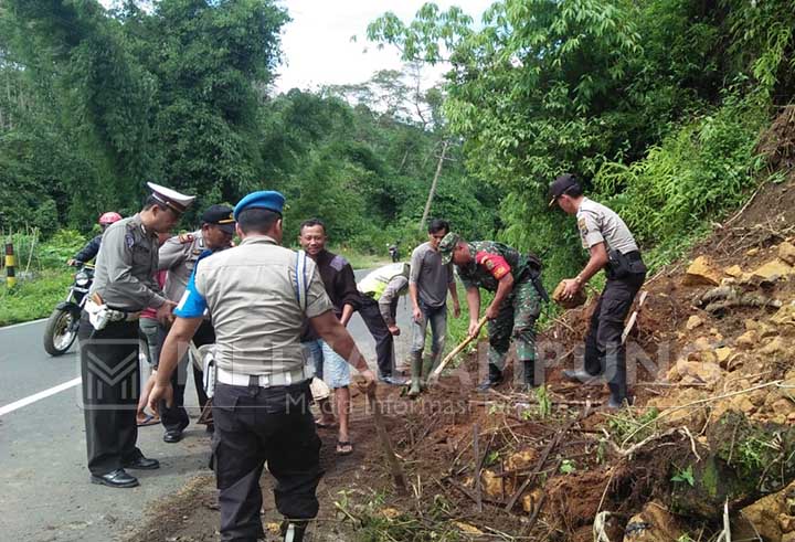 Personel Polsek Sekincau Bersihkan Material Longsor