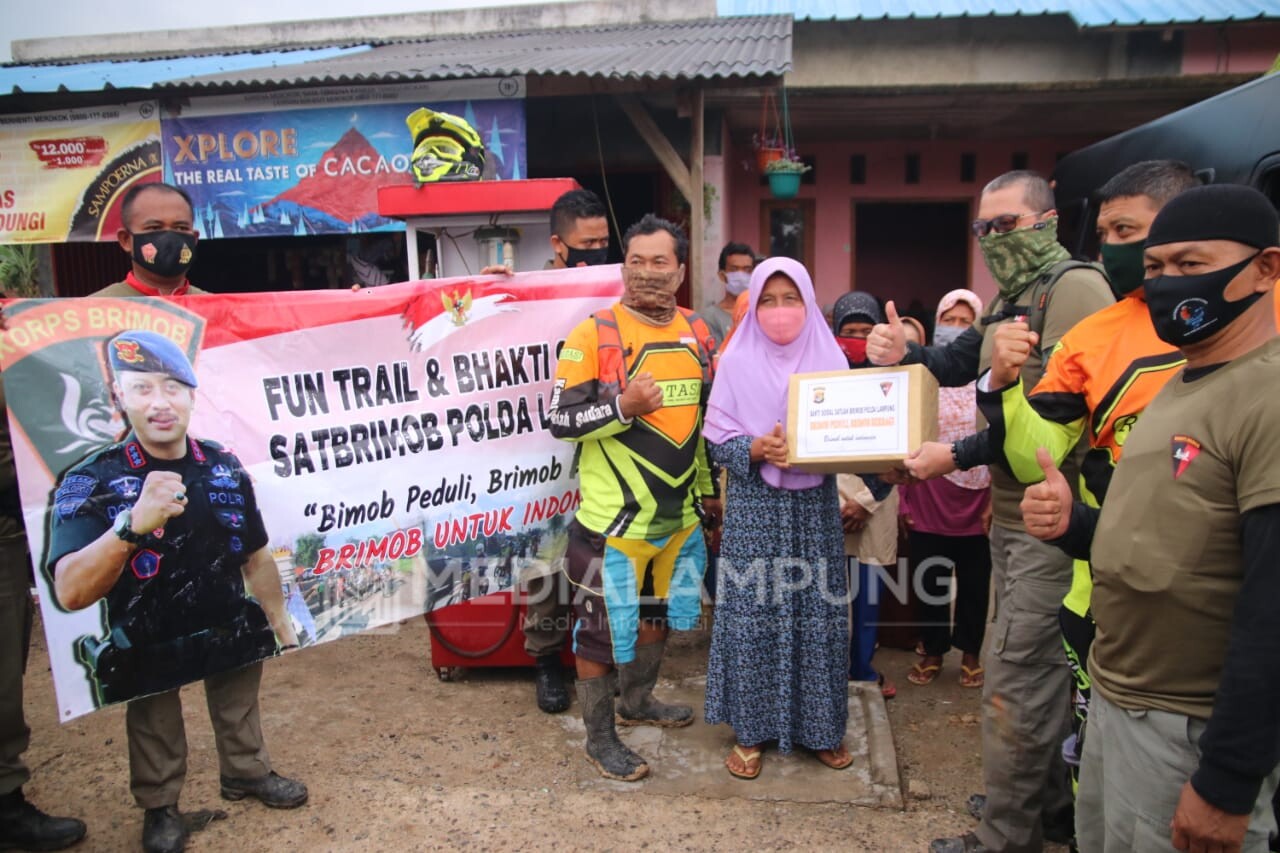 Bersama Komunitas Trail Tribal, Brimob Polda  Lampung Berbagi Sembako Untuk Warga