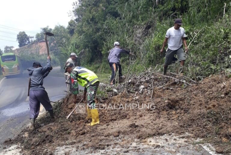 Babinsa-Warga Berjibaku Bersihkan Sisa Material Longsor di Jalan Nasional 