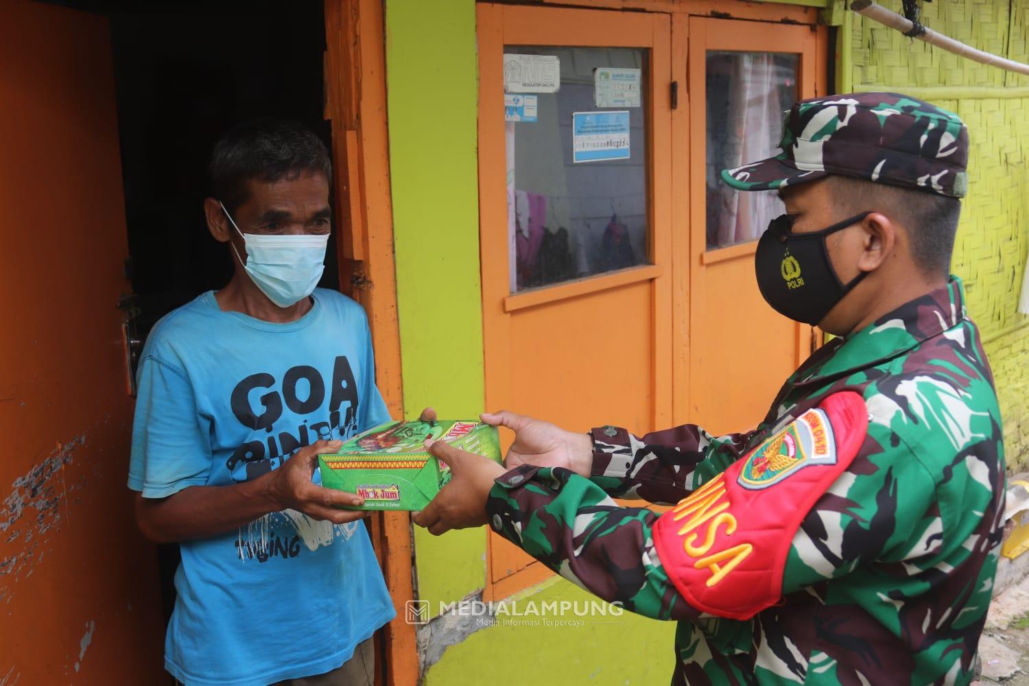 Personel Koramil TBU Bagikan Nasi Kotak dan Masker kepada Masyarakat Binaan