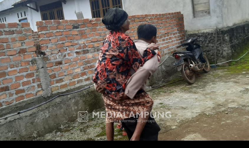 Perjuangan Bhabinkamtibmas Sukadamai Gendong Nenek Renta Menuju Gerai Vaksinasi